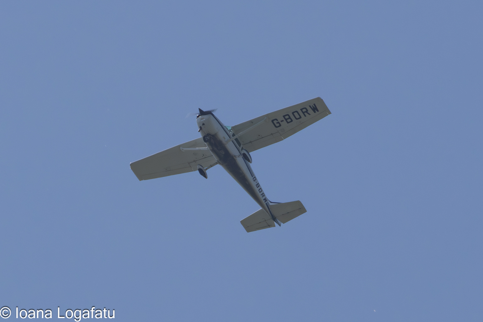 Vintage aircraft soars high above a clear sky